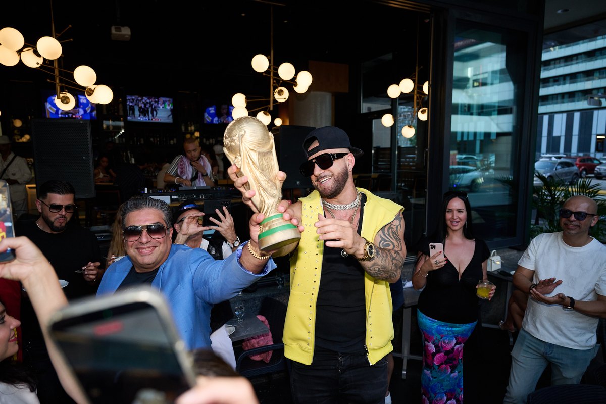 Guests celebrating with a World Cup trophy replica at the FIFA World Cup Final watch party